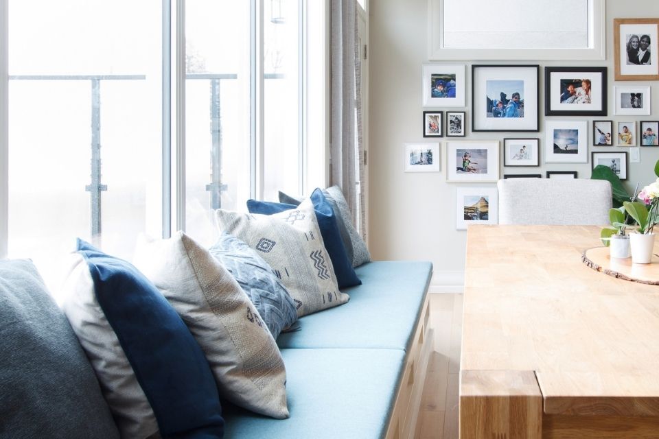 Blue kitchen seating with wooden table in open concept kitchen and dining